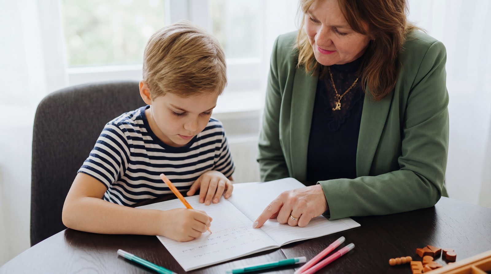 Mandy helpt een jongen met schrijven